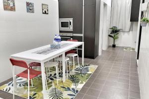 una cocina con mesa y taburetes en el suelo en Teratak Persona Homestay. 4 rooms double storey terrace in Kuantan City., en Kuantan