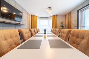 ViewMountain - Apartamenty Cieplice في يلينيا غورا: غرفة مؤتمرات كبيرة مع طاولة طويلة وكراسي