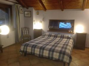 a bedroom with a bed with a checkered blanket at strada antica in Novalesa