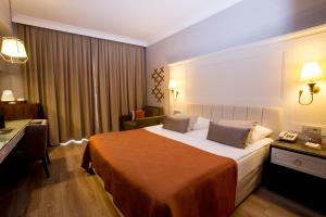 a hotel room with a bed and a desk at Fame Residence Kemer & Spa in Kemer