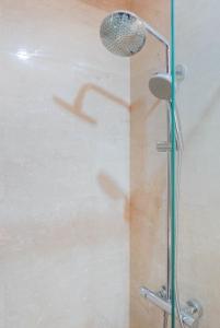 a shower with a shower head in a bathroom at Minimalist and Homey Studio Menteng Park Apartment By Travelio in Jakarta
