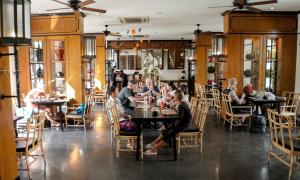 a group of people sitting at tables in a restaurant at Buri Siri Boutique Hotel in Chiang Mai
