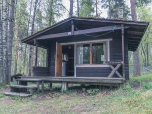 a wooden cabin with a wooden bench in the back at Camping Lappeenranta in Lappeenranta