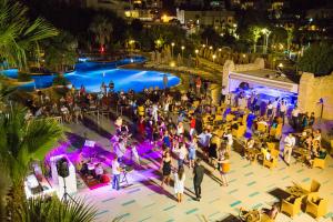 Une foule de gens debout autour d'une piscine la nuit dans l'établissement Salmakis Resort & Spa, à Bodrum City 63 autres photos