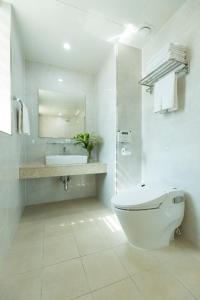 a white bathroom with a toilet and a sink at Hotel Nafore in Seoul
