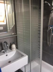 ein Bad mit einem Waschbecken und einer Glasdusche in der Unterkunft Lüttes Huus in Emden