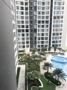 a view of a large building with a pool and palm trees at Luxury Condotel 2BR Vinhomes Skylake Keangnam - Netflix free in Hanoi