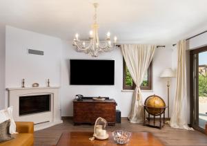 a living room with a television and a chandelier at Villa Luka in Višnjan