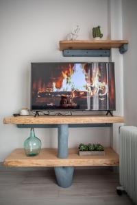 a tv on a stand with a fire behind it at Cielo in Sierra Nevada