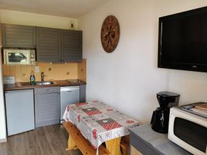 een kleine keuken met een tafel en een magnetron bij Studio le Grand-Bornand Village in Le Grand-Bornand