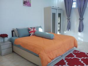 a bedroom with a bed with an orange blanket at Galleria Homestay Islamic Alor Setar in Alor Setar
