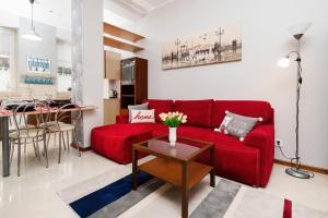 a living room with a red couch and a table at Apartments Old Town Ogarna 107 by Renters in Gdańsk