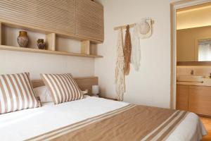 1 dormitorio con 1 cama con almohadas a rayas en Dionysos Village Hotel Marmaris, en Turunç
