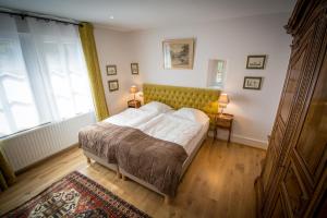 a bedroom with a bed with white sheets and a large window at Gite **** Le Meyerhof in Rorschwihr