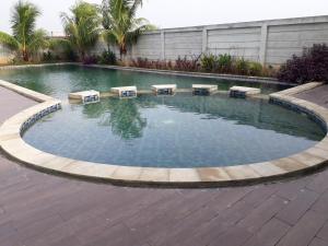 a swimming pool with tables in the water at ENVIRO Studio in Cikarang