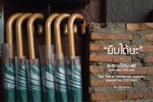 una fila de bates de béisbol de madera sentados junto a una pared de ladrillo en Botanic Service Room at Impact Muangthongthani - SHA Certified en Nonthaburi