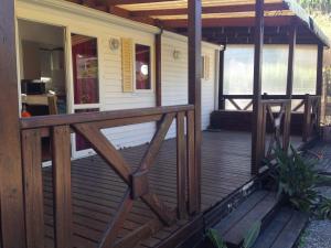 a front porch of a house with a wooden deck at Mobilhome sur camping le kontiki **** ramatuelle in Saint-Tropez