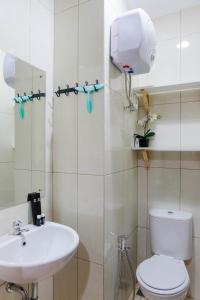 a bathroom with a toilet and a sink at Convenient and Luxurious 2BR Asatti Apartment By Travelio in Pagedangan