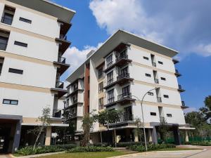 a white apartment building with balconies on it at Convenient and Luxurious 2BR Asatti Apartment By Travelio in Pagedangan