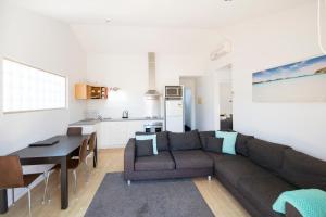 ein Wohnzimmer und eine Küche mit einem Sofa und einem Tisch in der Unterkunft Archipelago Apartments Esperance in Esperance
