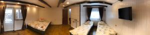 Habitación con 2 camas y TV en la pared. en Cottage v Gorakh en Izki