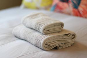 a pile of towels sitting on top of a bed at 読谷村カービラハウス ow4 in Jima +38 photos