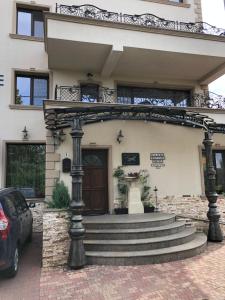 a house with a gate and stairs in front of it at Hotel Aviator Boutique in Otopeni