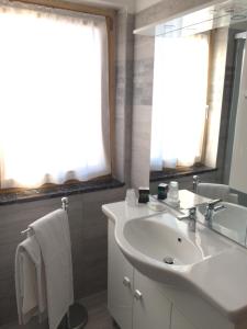 a white bathroom with a sink and a mirror at Da Alsido in Camporosso in Valcanale