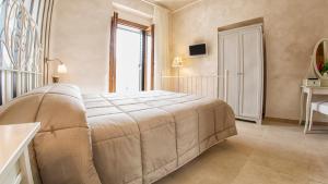 a bedroom with a large bed and a window at Relais La Pretura in Vieste