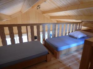 una camera con due letti in una mansarda in legno di Cabanes et Lodges du Belvedere a Serrières-sur-Ain