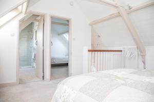 a bedroom with a white bed and a bathroom at The Old Chapel in Marlborough