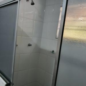 a shower with a glass door in a bathroom at Pousada Recanto do Morro in Cananéia