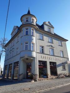 un gran edificio con una torre encima en Pension Schöne, en Großröhrsdorf