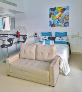a bedroom with a white bed and a couch at Sifah Resort Studio in As Sīfah