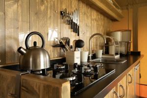 a kitchen with a stove with a tea kettle on it at Tall Trees Glamping in Baltonsborough