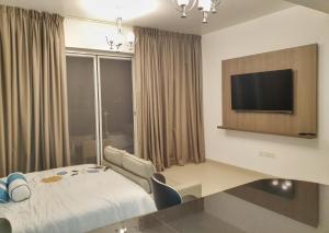 a hotel room with a bed and a flat screen tv at Sifah Resort Studio in As Sīfah +9 photos