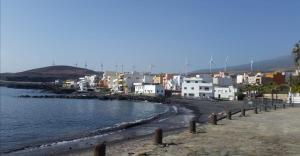 - une vue sur la plage, les bâtiments et l'eau dans l'établissement BLUE SEA. TONY FRÍAS. LAS ERAS. ARICO - TENERIFE., à Arico el Nuevo