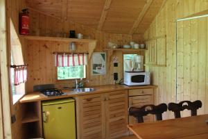 a small kitchen with a sink and a microwave at Domaine De Syam - Gîtes, Chambres d'hôtes & Cabanes in Syam