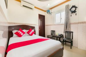 a bedroom with a bed and a window and a clock at NGAN HA Hotel in Ho Chi Minh City