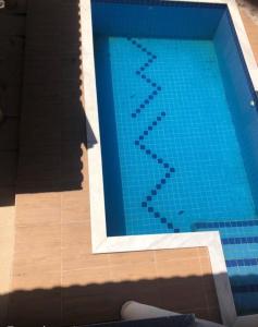 a large blue swimming pool in a building at Conforto e Comodidade Porto Seguro BA in Porto Seguro