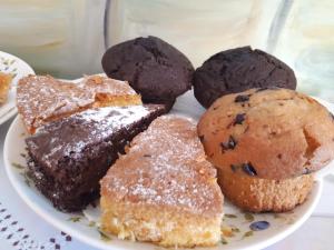 een bord chocolademuffins en muffins op een tafel bij Sicilia In Miniatura "L'Atelier dell'Etna" in Zafferana Etnea