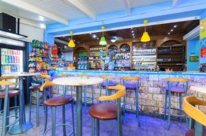 a bar with colorful stools and tables in a restaurant at Aeon Hotel in Laganas