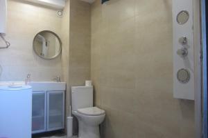 een badkamer met een toilet en een spiegel bij Studio Downtown Oporto in Porto