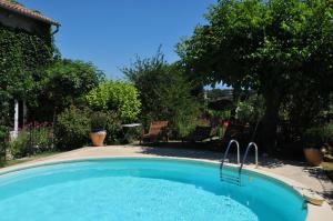 una piscina en un patio con sillas y árboles en Chambres d'Hôtes et Gîtes Le Mas Mellou, en Orange