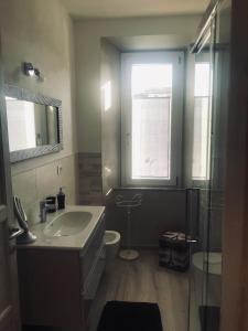 uma casa de banho com um lavatório, um espelho e uma janela em Domus Zoe em Forte dei Marmi