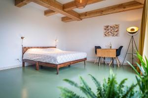 een slaapkamer met een bed, een tafel en stoelen bij Wijngaard de Kroon van Texel in Den Burg