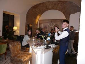 a man standing in front of a table holding a wine glass at Hotel Milton Roma in Rome