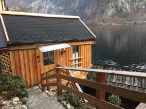 een houten hut op een steiger naast een waterlichaam bij Bootshaus am Hallstätter See in Hallstatt