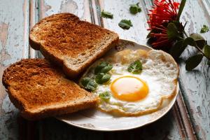 un plato con un huevo y dos rodajas de tostadas en Hoi An Love.Ly Hostel en Hoi An