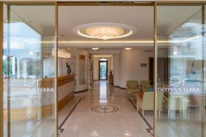 un couloir dans un bâtiment doté d'une porte en verre dans l'établissement Olympus Terra Boutique Hotel, à Larissa